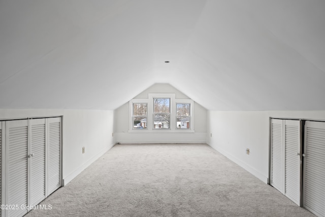 bonus room with lofted ceiling, carpet flooring, and baseboards