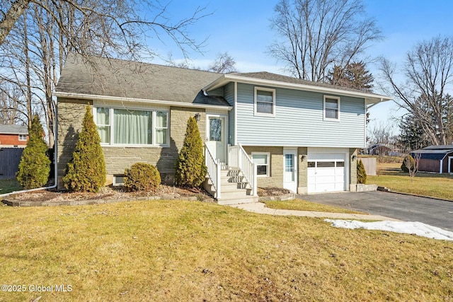 split level home with a front yard, brick siding, a garage, and driveway