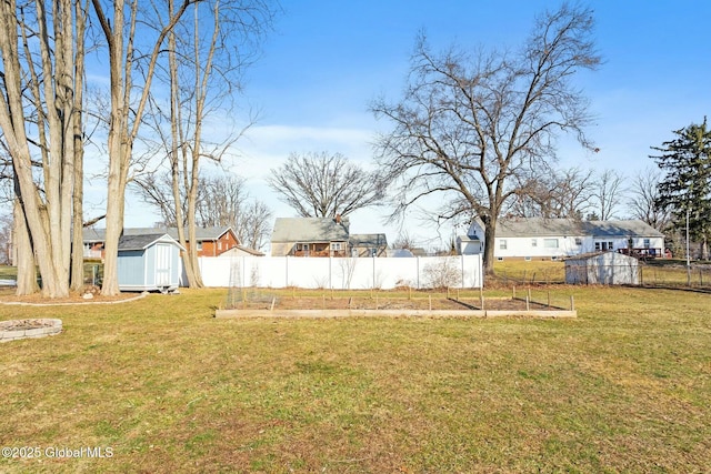 view of yard with a shed, a vegetable garden, and fence