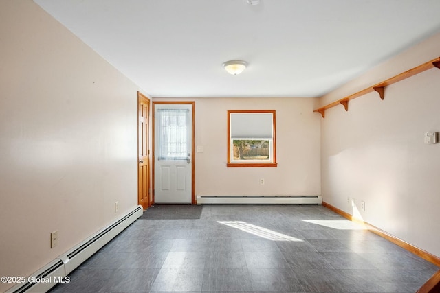 unfurnished room with a baseboard heating unit, tile patterned floors, and baseboards