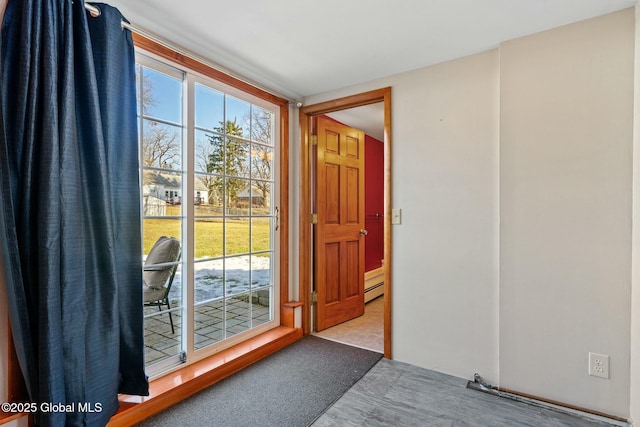 doorway to outside with a baseboard heating unit and carpet floors