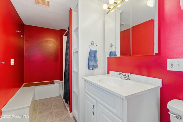 bathroom featuring tile patterned flooring, visible vents, toilet, and vanity