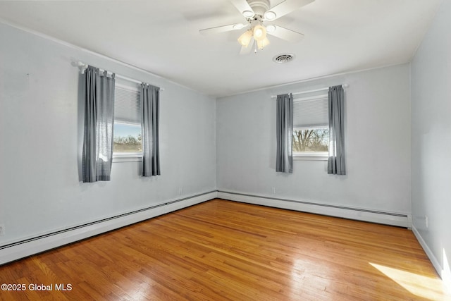 empty room with a ceiling fan, visible vents, baseboard heating, and light wood-type flooring