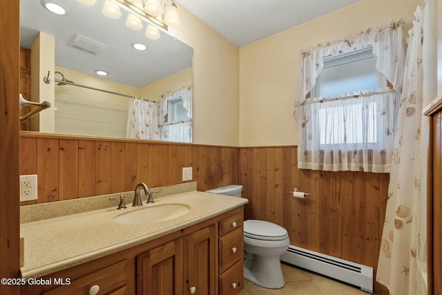 full bathroom featuring tile patterned flooring, toilet, baseboard heating, wainscoting, and vanity