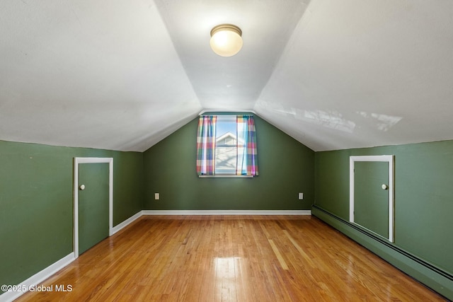 bonus room with lofted ceiling, wood finished floors, baseboards, and baseboard heating