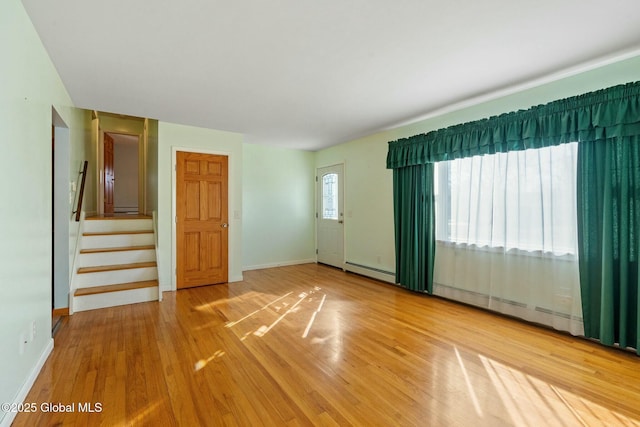 spare room with stairs, baseboards, and wood finished floors