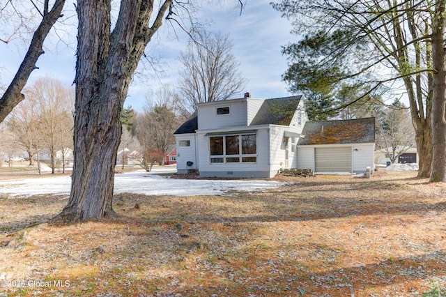 view of front of home with crawl space, a chimney, and roof with shingles