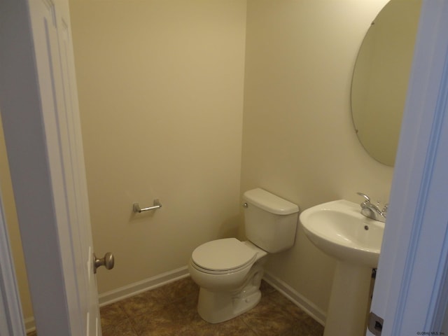 bathroom with tile patterned floors, baseboards, and toilet