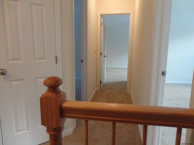 corridor with baseboards and light carpet