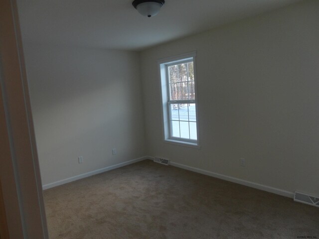 unfurnished room with visible vents, baseboards, and carpet floors