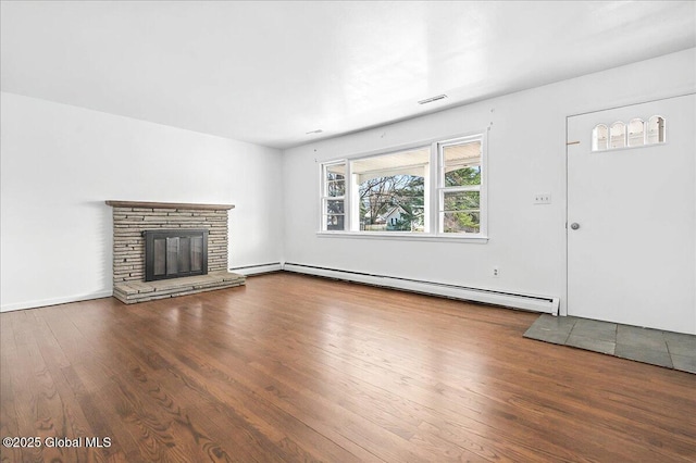 unfurnished living room with a stone fireplace, wood finished floors, and a baseboard radiator