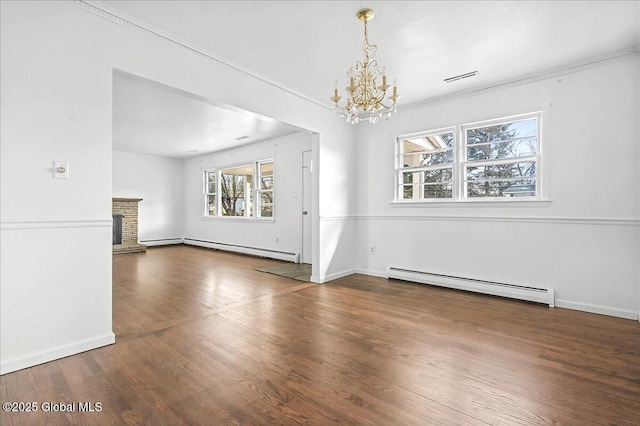 interior space featuring a baseboard heating unit, a brick fireplace, wood finished floors, and a chandelier