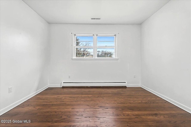 unfurnished room featuring a baseboard heating unit, baseboards, visible vents, and wood finished floors