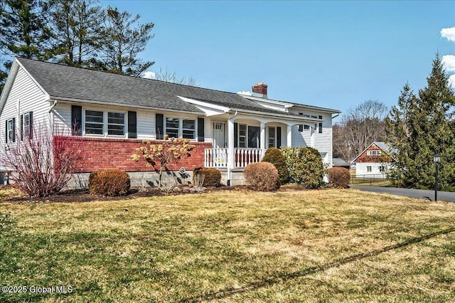 view of front of home featuring brick siding, a porch, a chimney, and a front yard