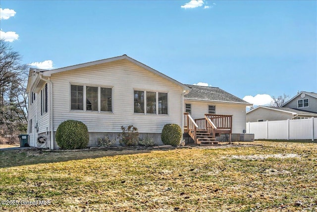 back of house with a deck, a yard, and fence