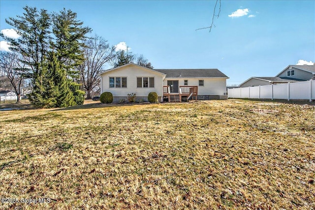 rear view of house featuring crawl space, a lawn, a deck, and fence