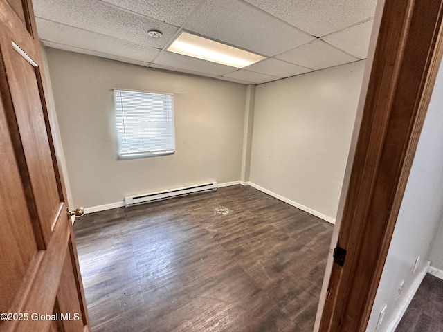 unfurnished room featuring a paneled ceiling, dark wood-style floors, baseboards, and a baseboard radiator