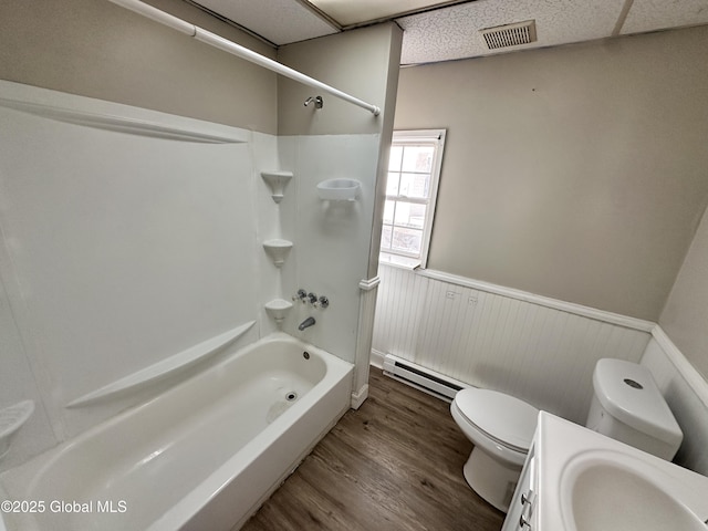 bathroom featuring visible vents, a wainscoted wall, toilet, wood finished floors, and baseboard heating