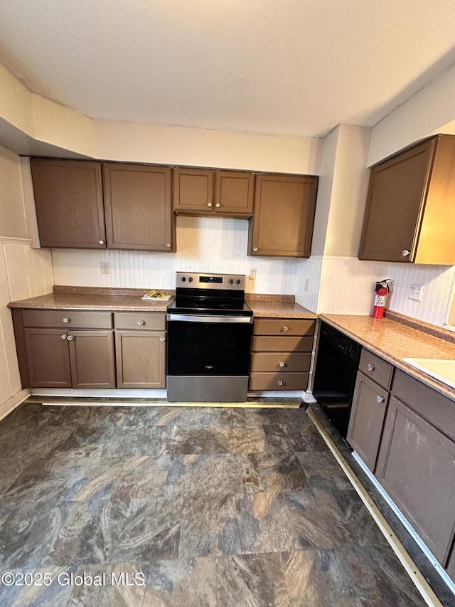 kitchen with a wainscoted wall, stainless steel electric range, black dishwasher, and a sink