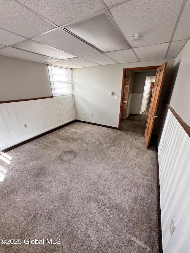 spare room featuring a wainscoted wall, a paneled ceiling, and carpet floors