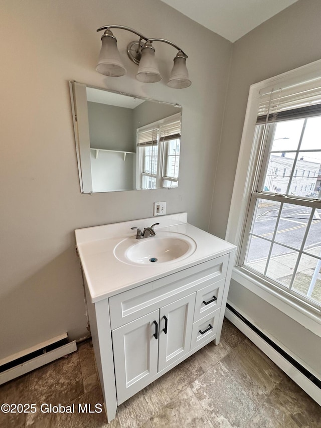 bathroom featuring vanity, a healthy amount of sunlight, baseboard heating, and a baseboard radiator