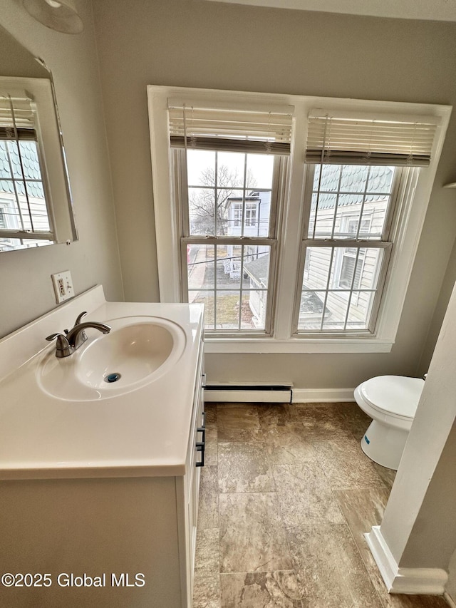 bathroom with vanity, a wealth of natural light, and a baseboard radiator