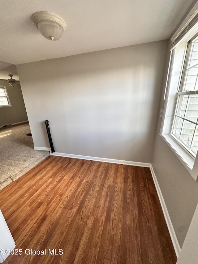 spare room featuring wood finished floors and baseboards