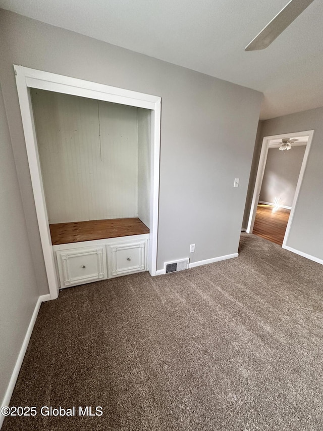 unfurnished bedroom featuring carpet flooring, baseboards, visible vents, and a closet