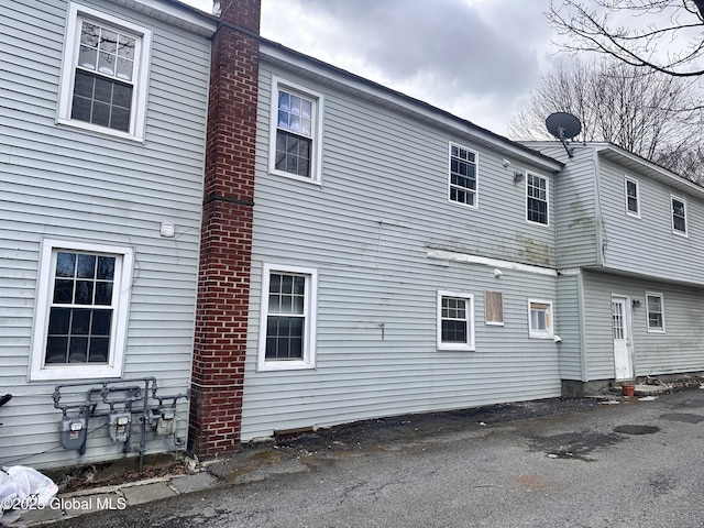 back of house featuring a chimney