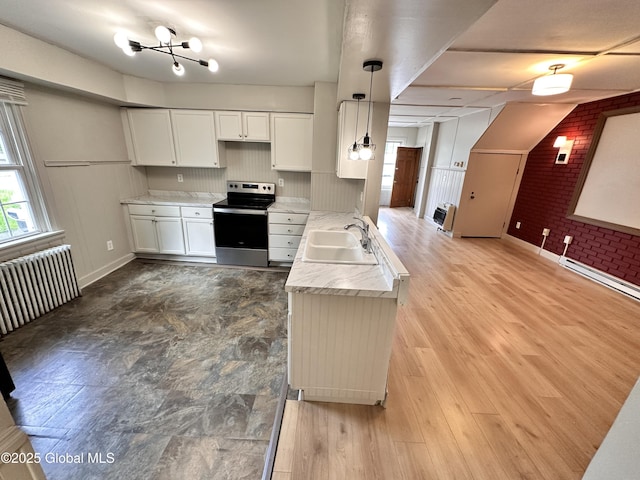 1 S Main St, Voorheesville, NY 12186 - kitchen featuring stainless steel electric stove, radiator heating unit, white cabinetry, pendant lighting, and brick wall