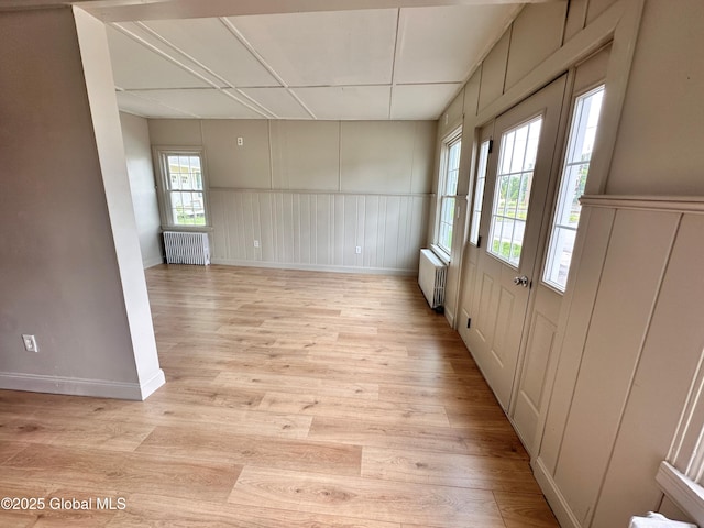 1 S Main St, Voorheesville, NY 12186 - spare room with radiator heating unit, light wood-type flooring, a decorative wall, and a wainscoted wall