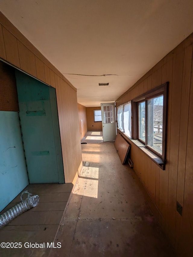 hallway with wooden walls and visible vents