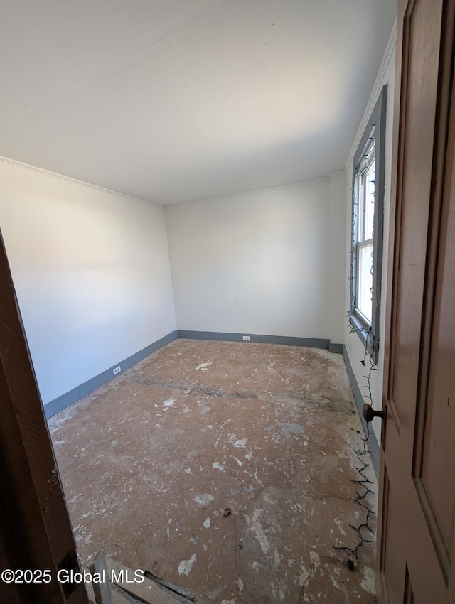 unfurnished room with baseboards