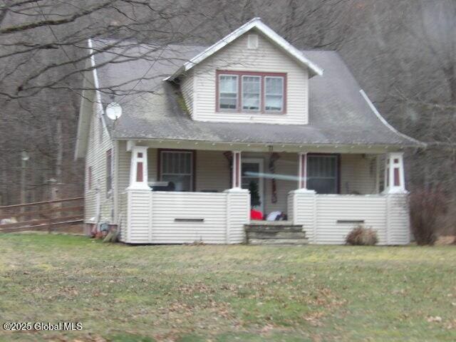 view of front of home with a porch and a front yard