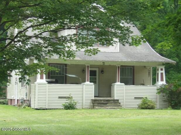 view of front of house with a front yard and covered porch