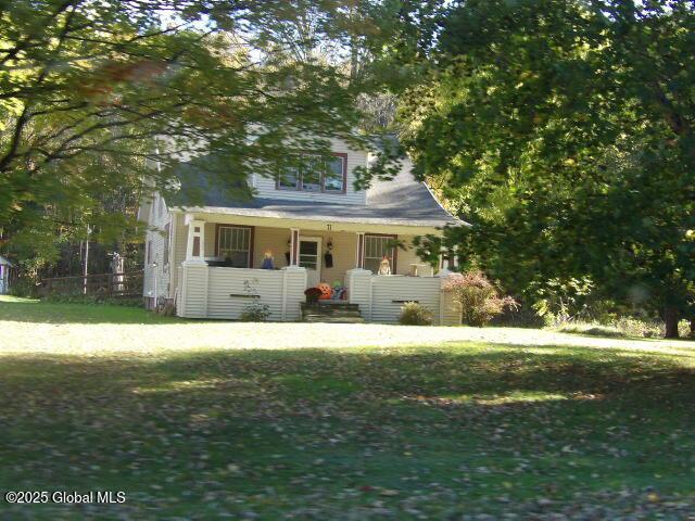 view of front of property featuring a front yard and covered porch