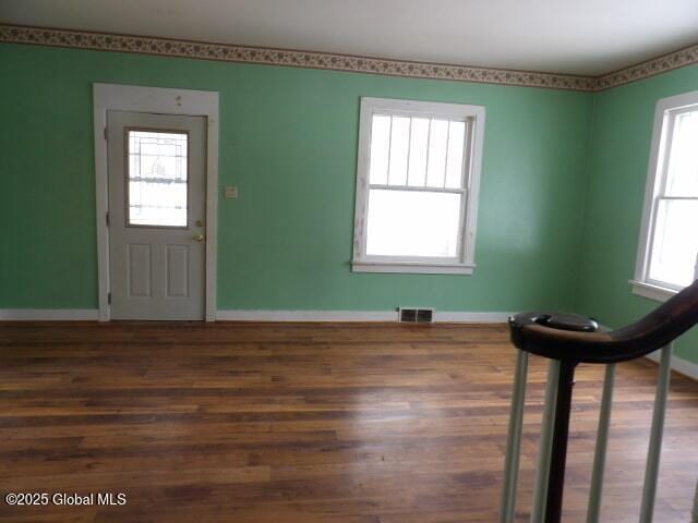 foyer entrance with visible vents, baseboards, and wood finished floors