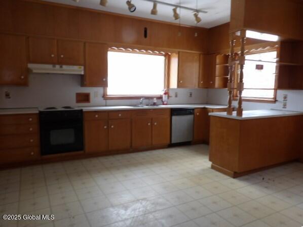 kitchen with open shelves, under cabinet range hood, light countertops, stainless steel dishwasher, and range