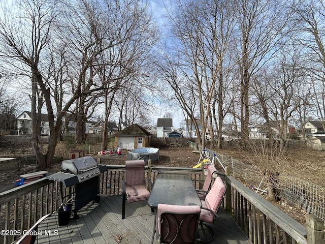 deck featuring a grill, a storage shed, and an outdoor structure