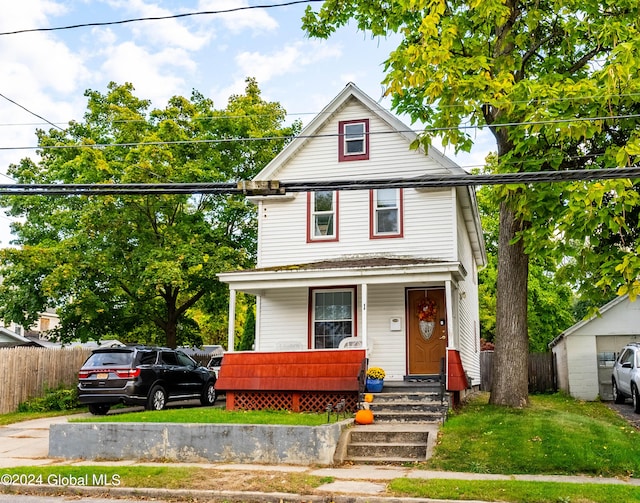 view of front of house featuring a porch, a front yard, and fence