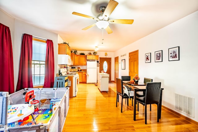 dining space with visible vents, baseboards, light wood-style floors, and a ceiling fan