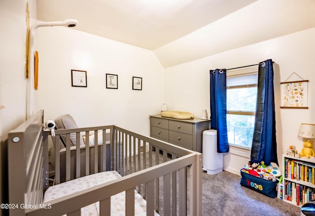 bedroom featuring lofted ceiling, a nursery area, and carpet