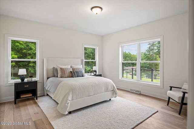 bedroom featuring visible vents, light wood-style flooring, and baseboards