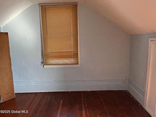 additional living space with baseboards, lofted ceiling, and hardwood / wood-style flooring