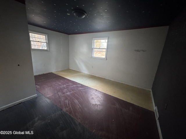 empty room featuring a wealth of natural light and baseboards