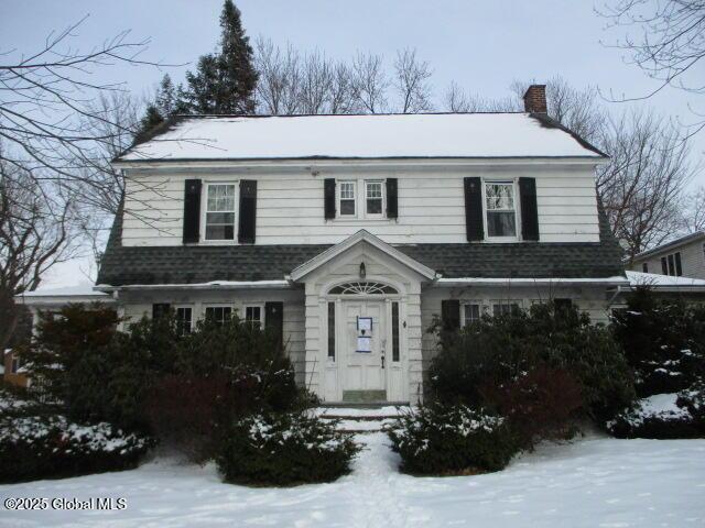 view of front of home with roof with shingles and a chimney