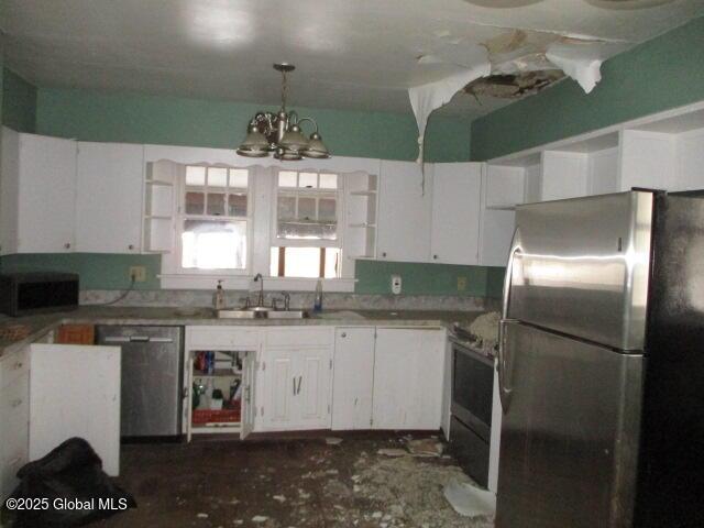 kitchen with a sink, hanging light fixtures, white cabinets, stainless steel appliances, and open shelves