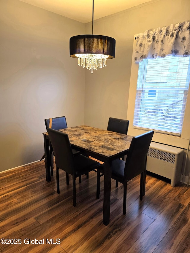 dining area with a chandelier, radiator, and dark wood-style floors