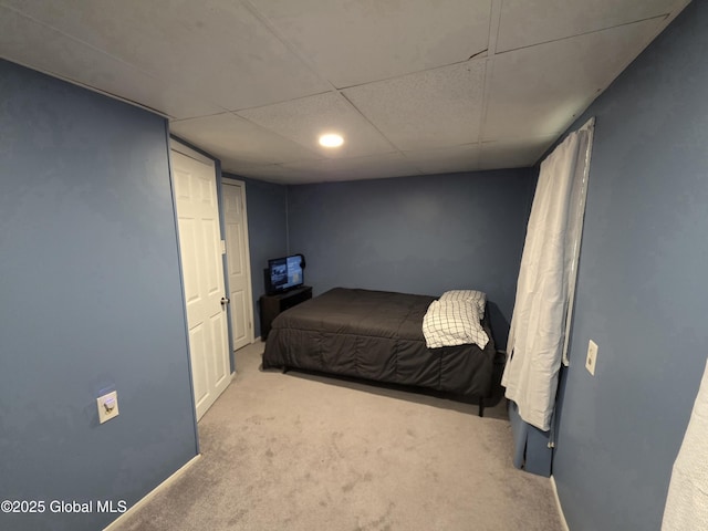 carpeted bedroom with a paneled ceiling