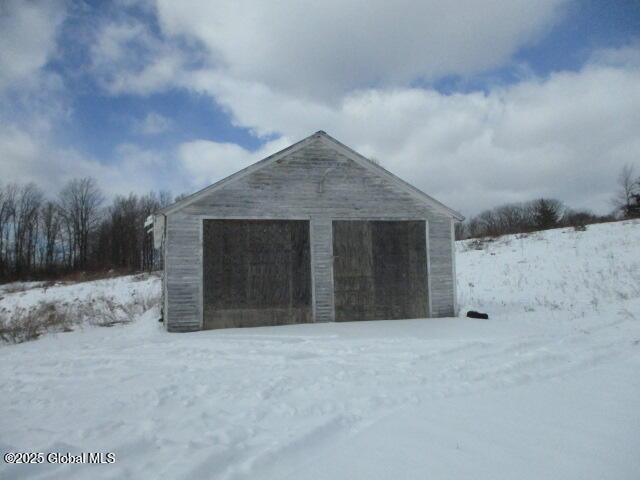 snow covered garage with a garage